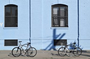 two bicycles parked in front of blue building